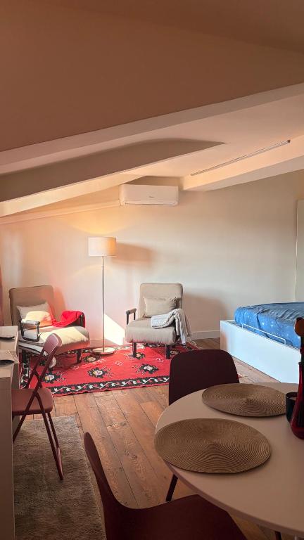 a living room with chairs and a bed and a rug at Asterisco Casa Vacanze in Turin
