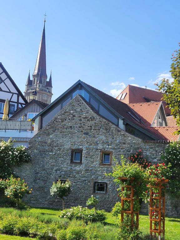 an old stone building with a church in the background at Ferienwohnung Überblick -mit Klimaanlage in Radolfzell am Bodensee