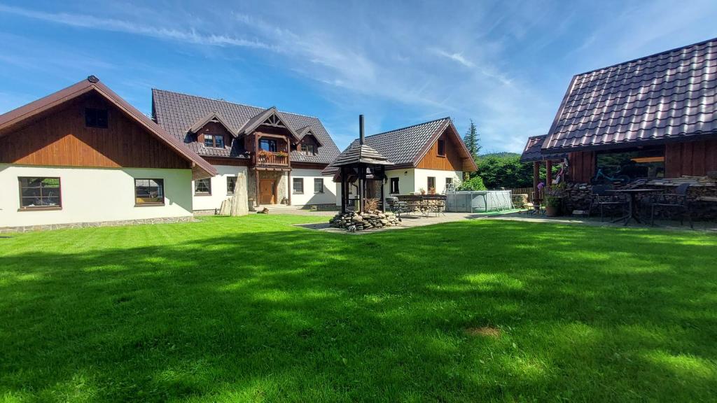 a house with a large yard with green grass at Domek u Hillów in Stronie Śląskie