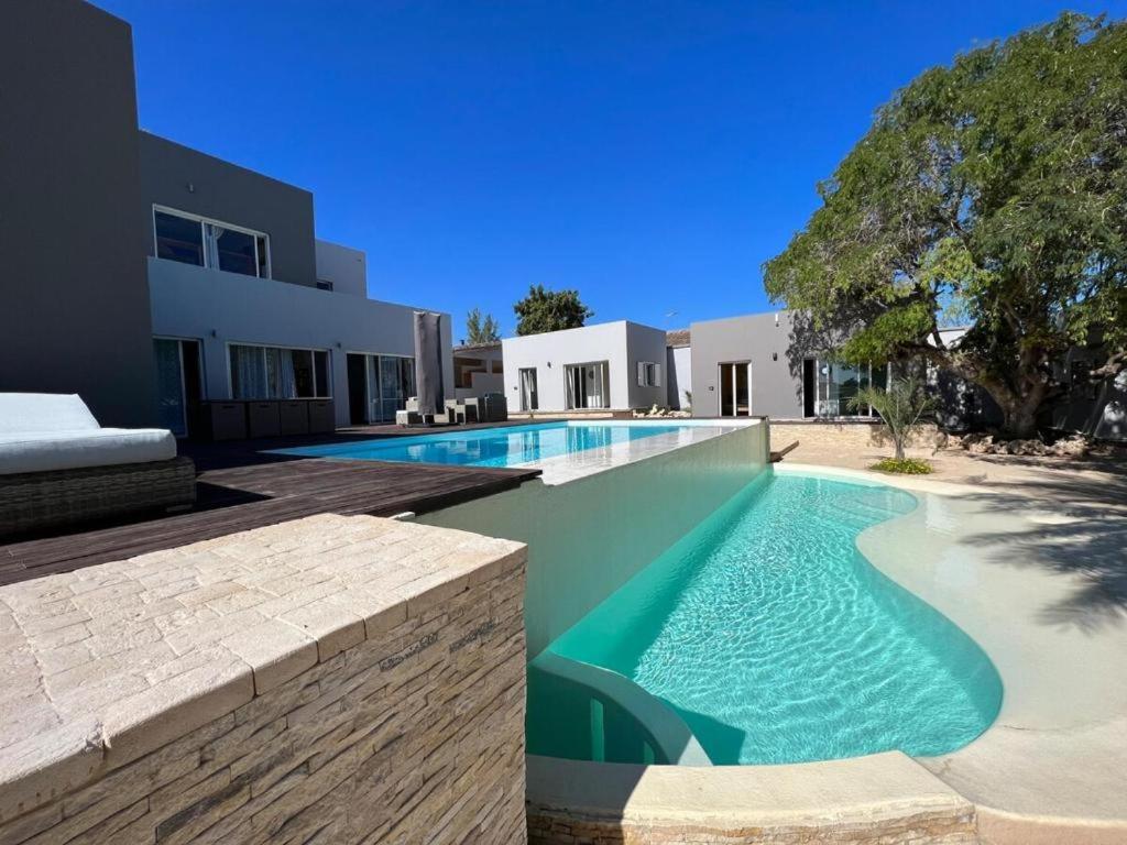 a swimming pool in front of a house at Villa Céllia in Tsivonoakely