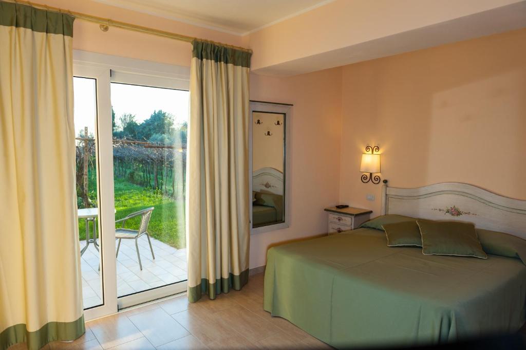 een slaapkamer met een bed en een glazen schuifdeur bij Agriturismo il Grappolo in Lazise