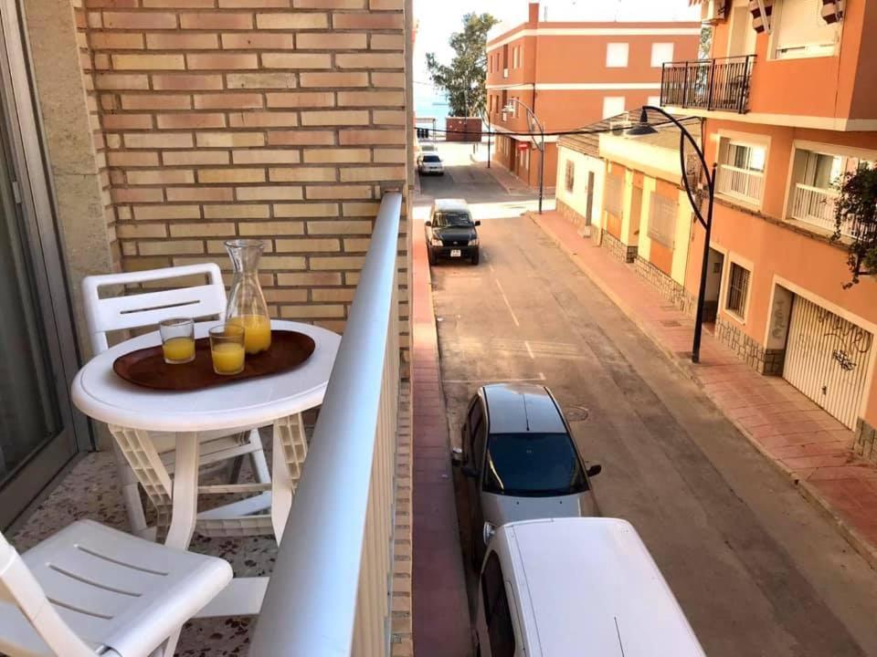 a balcony with a table and a car on a street at Apartamentos Pagán Alejandro in San Javier