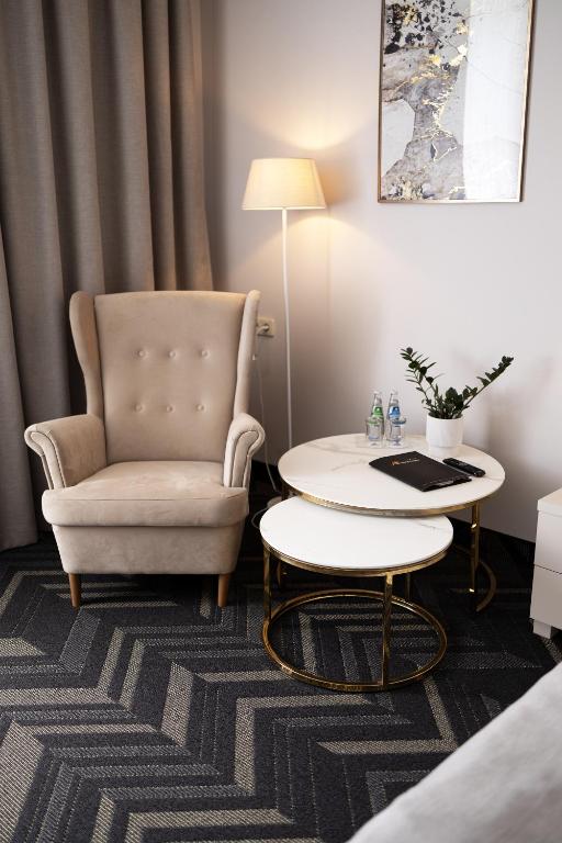 a living room with a chair and a table at Aviator Hotel in Radom