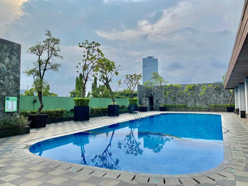 a large blue swimming pool on top of a building at Whiz Prime Hotel Kelapa Gading in Jakarta