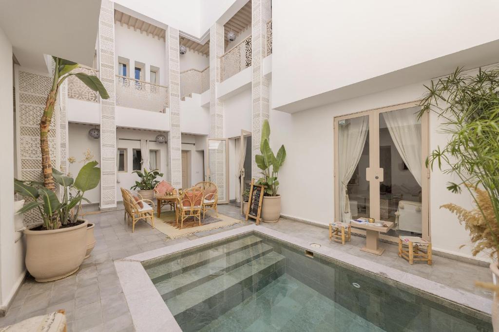 a living room with a swimming pool and a house at Riad Origines in Marrakesh