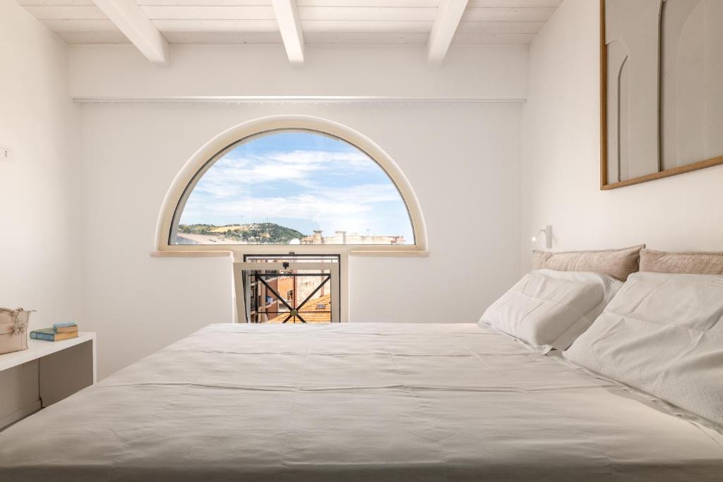 a bedroom with a large bed and an arch window at Suite 33 - Boutique Apartments in San Benedetto del Tronto