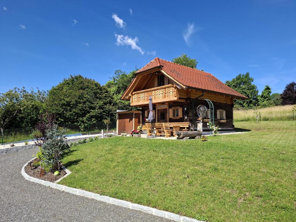 a log cabin with a grass yard in front of it at Haus Sunnseit'n in Pöllauberg