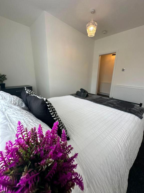 a bedroom with a white bed with purple flowers on it at Spacious Two Bed House With Stunning View. in Paull