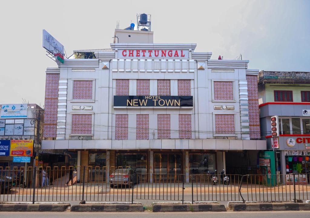 a large white building with a new town sign on it at The Hotel Chettungal in Angamaly