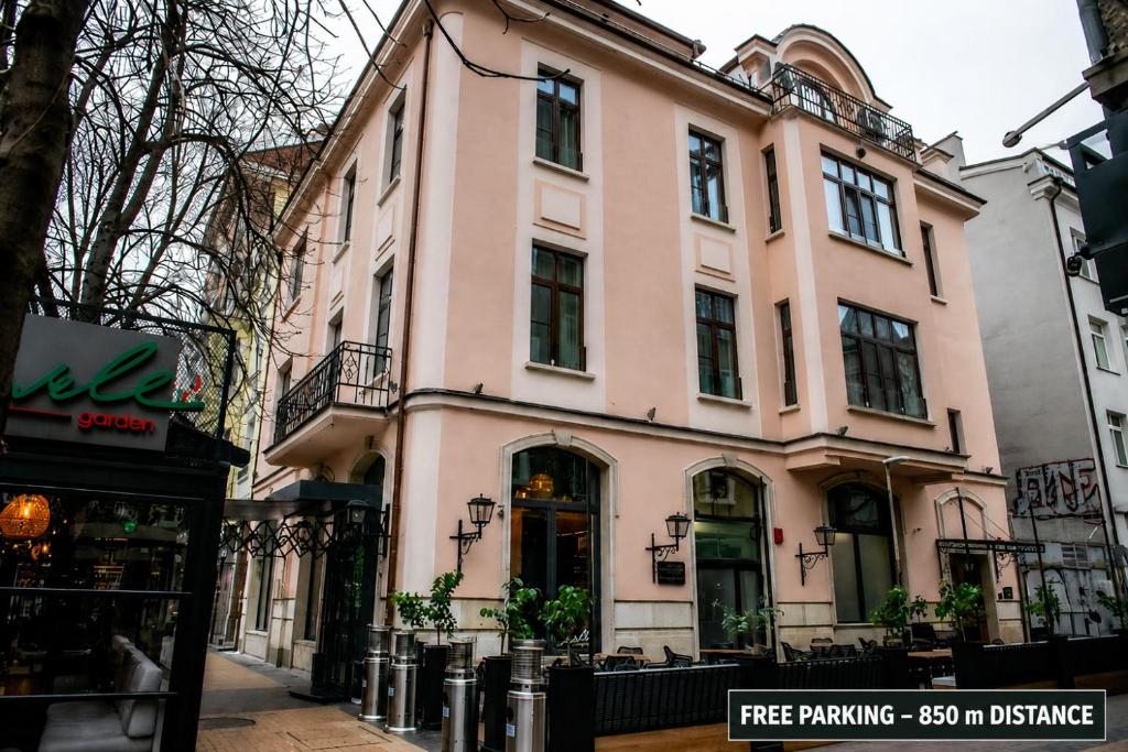 a large pink building on a city street at Agora Boutique Hotel in Sofia