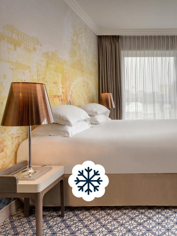 a bedroom with a bed and a table with a lamp at Célestins Spa Thermal & Hôtel by Vy Resort in Vichy