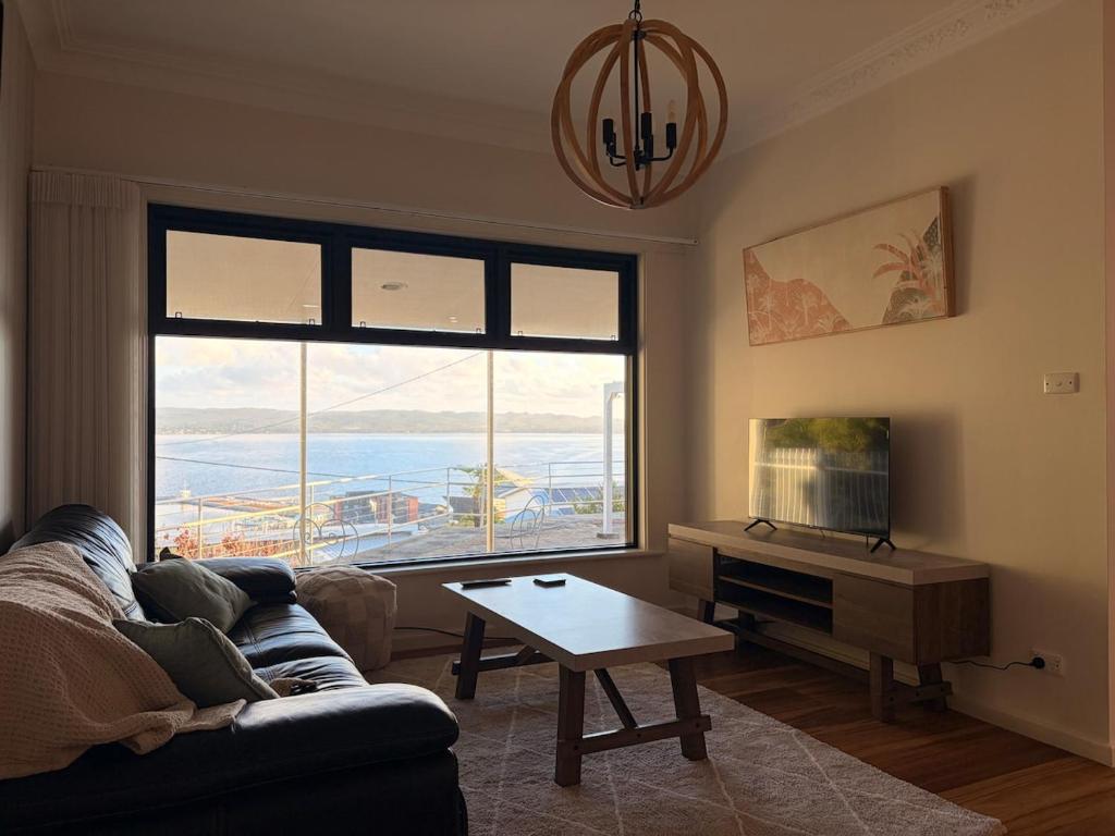 a living room with a couch and a table and a large window at The Panorama On Earl in Albany