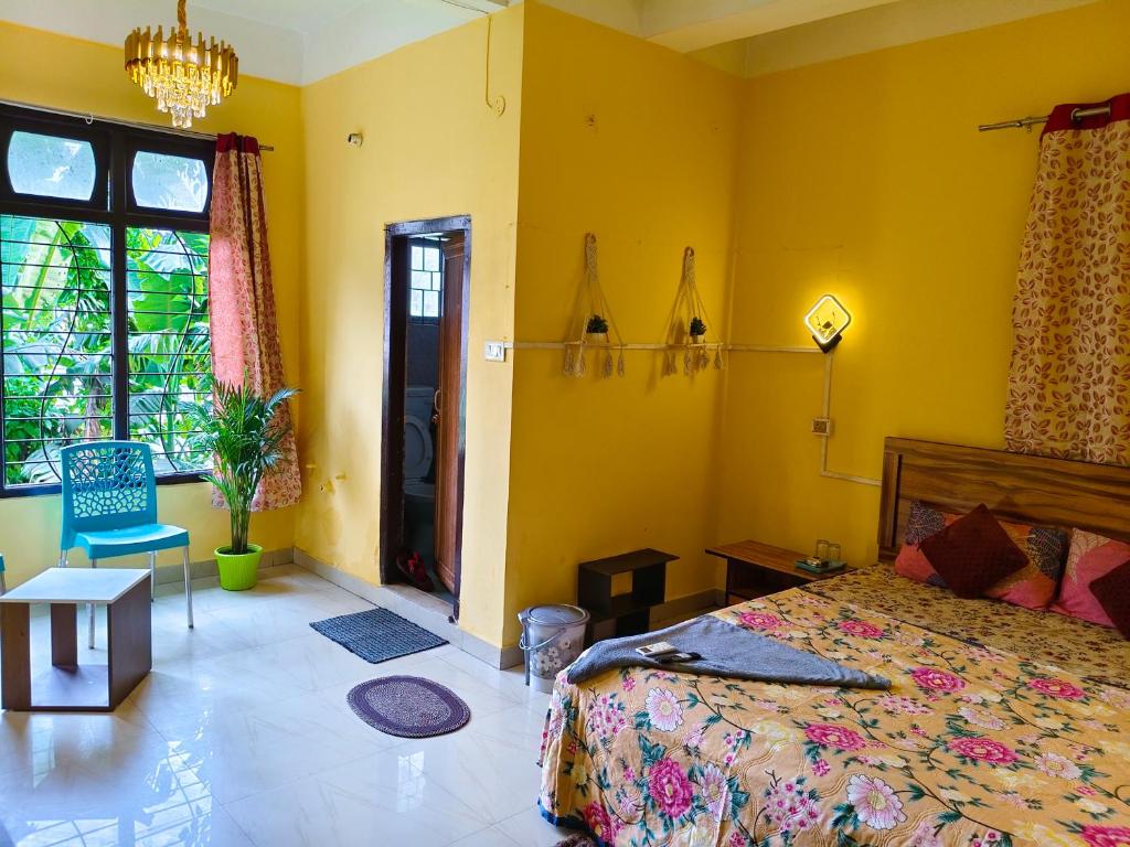 a bedroom with a bed and a yellow wall at Mon Aashray Stay in Guwahati