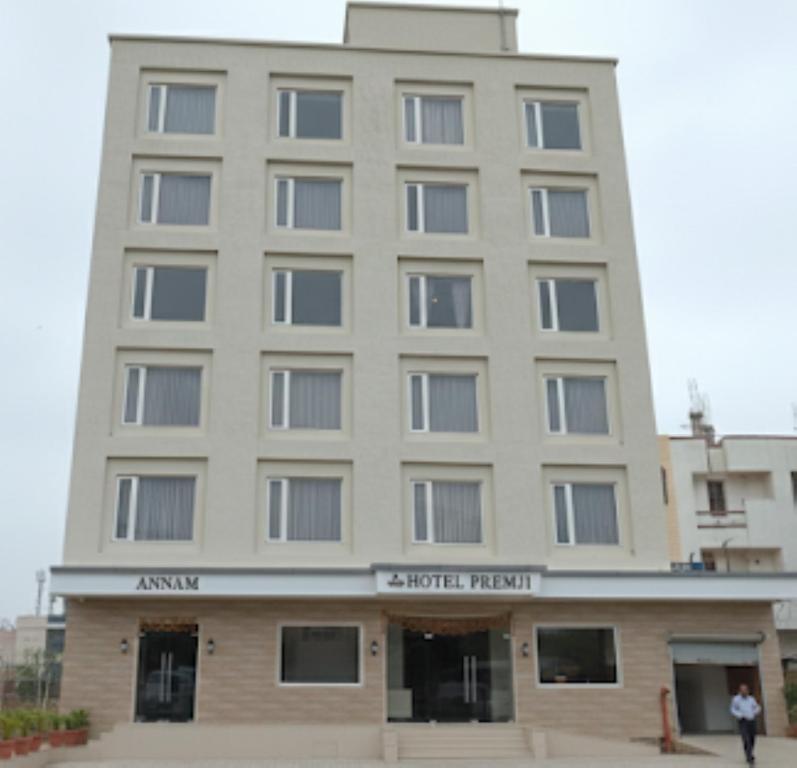 a building with a man standing in front of it at Hotel Premji, Dwarka in Dwarka