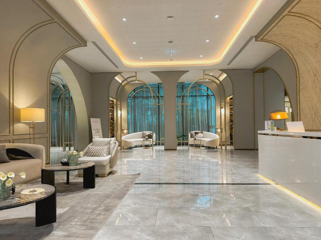 a lobby with chairs and tables in a building at Hampton Sriracha in Si Racha
