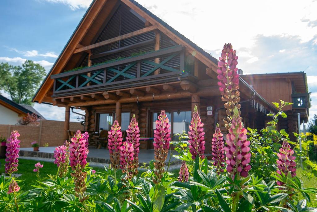 a garden with pink flowers in front of a house at Zrub Kriváň Chalet with Mountain View in Závažná Poruba