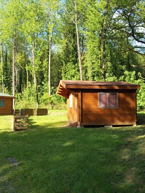 a small cabin in the middle of a grass field at Chanterelle in Comblessac