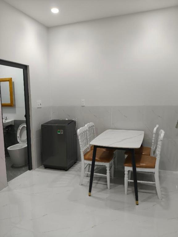 a table and chairs in a bathroom with a toilet at Phú Hưng Gia Motel in Ðức Hòa
