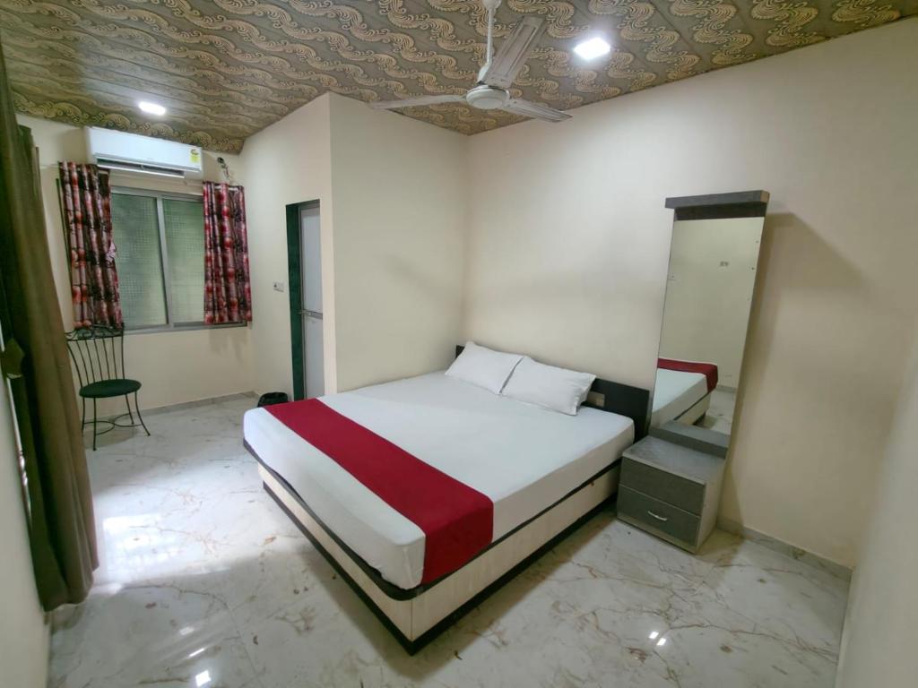 a bedroom with a bed and a chair in it at Hotel Garden View - Andheri West in Mumbai
