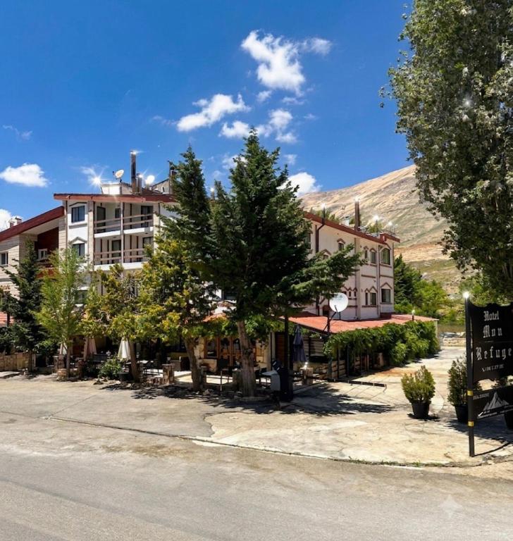 a hotel on the side of a street with a mountain in the background at Mon Refuge 120 in Bcharré