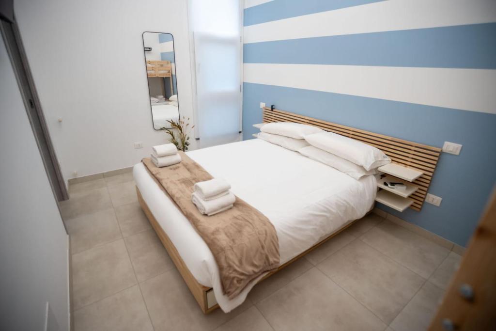 a bedroom with a bed with white sheets and a mirror at Bilo 66 in Palmi