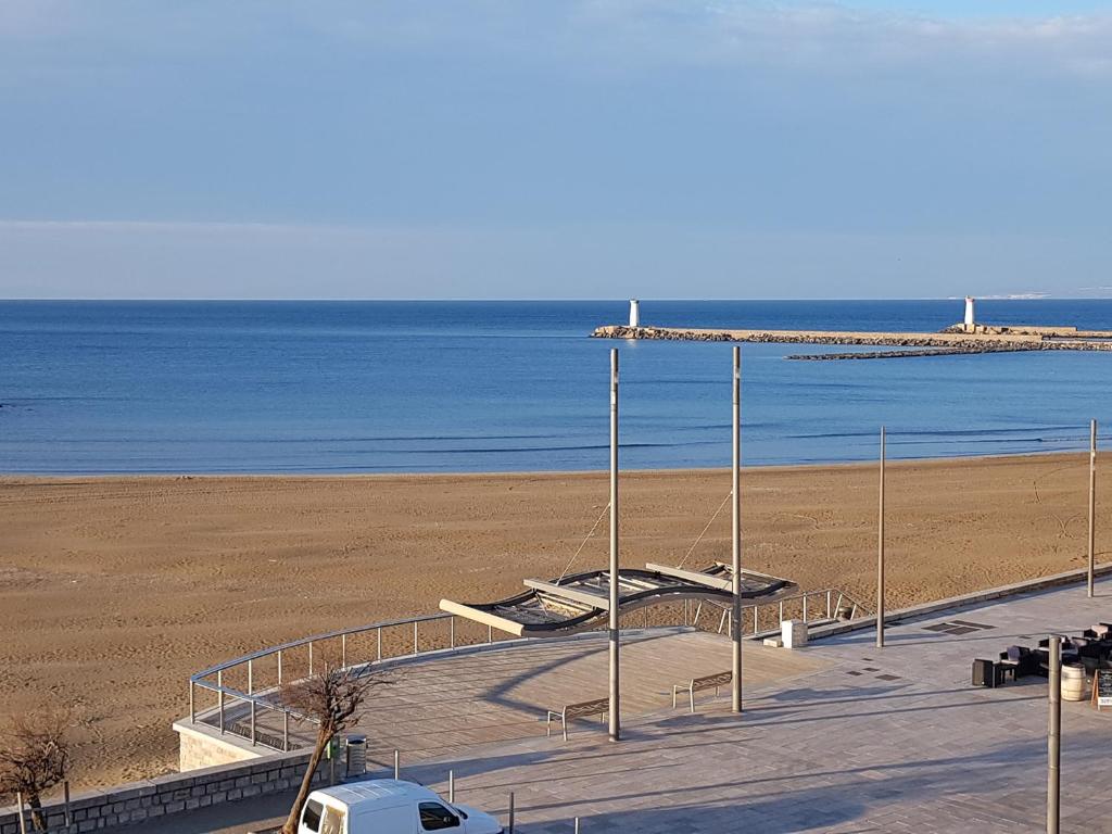 a view of a beach with two beds and the ocean at SUPERBE VUE sur la MER in Le Grau-dʼAgde
