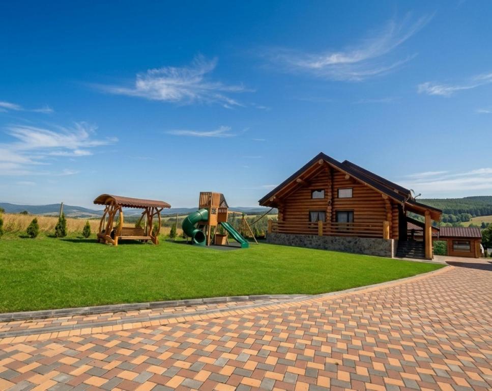 a log cabin with a playground and a house at Cabana Bocus in Păltinoasa