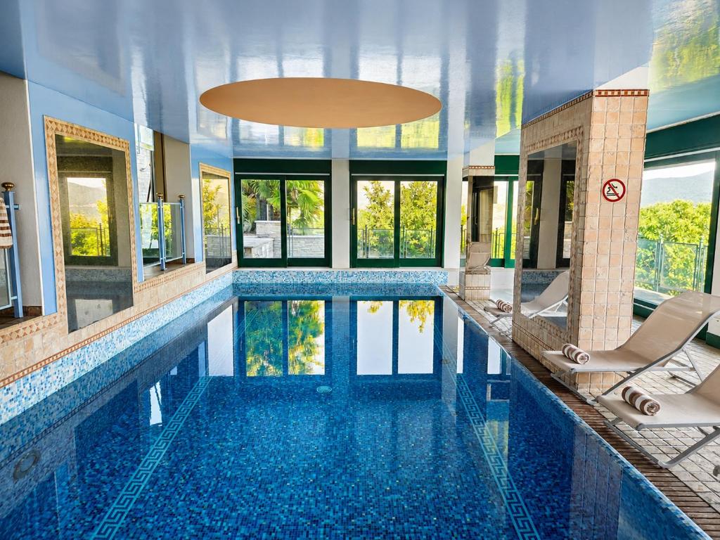 a pool in a house with two chairs and a swimming pool at Villa Spa Chiara Luna by Lago Reisen in Oggebio