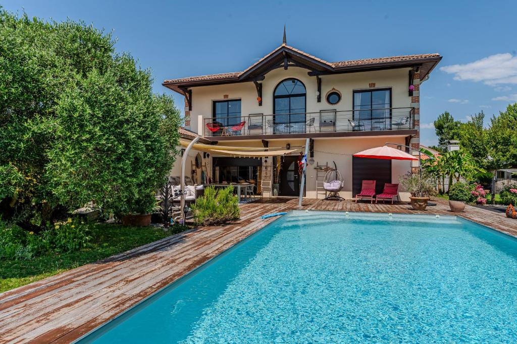 a house with a swimming pool in front of a house at Tomland in Parentis-en-Born