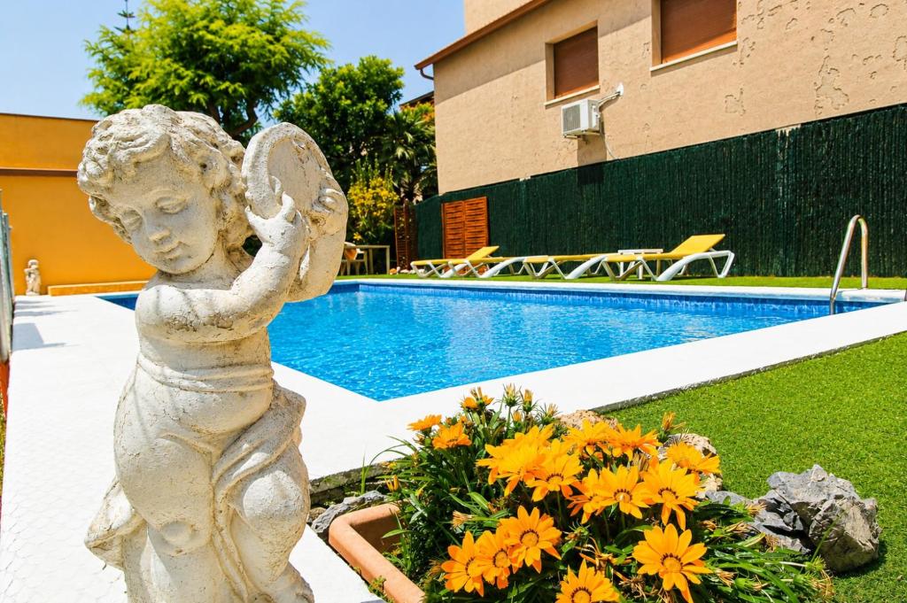 a statue of a girl holding a butterfly next to a pool at Pool and sea 20' from Barcelona in Premiá de Mar