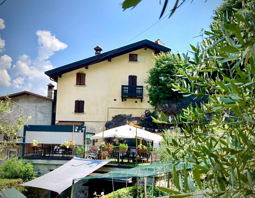 a building with tables and umbrellas in front of it at La Casa sulla Roccia in Pisogne
