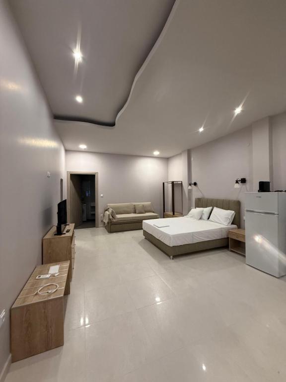 a large bedroom with a bed and a couch at Fatses in Nea Plagia