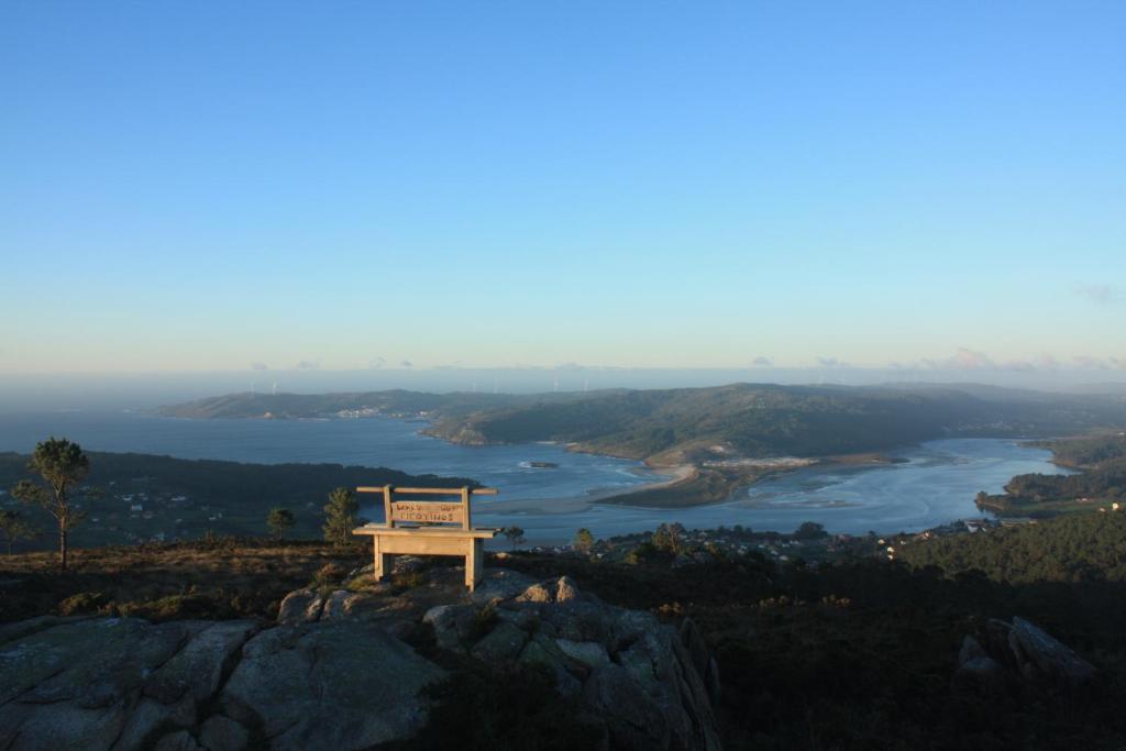 a bench sitting on top of a mountain overlooking a river at Fogar dos Americanos in Borneiro