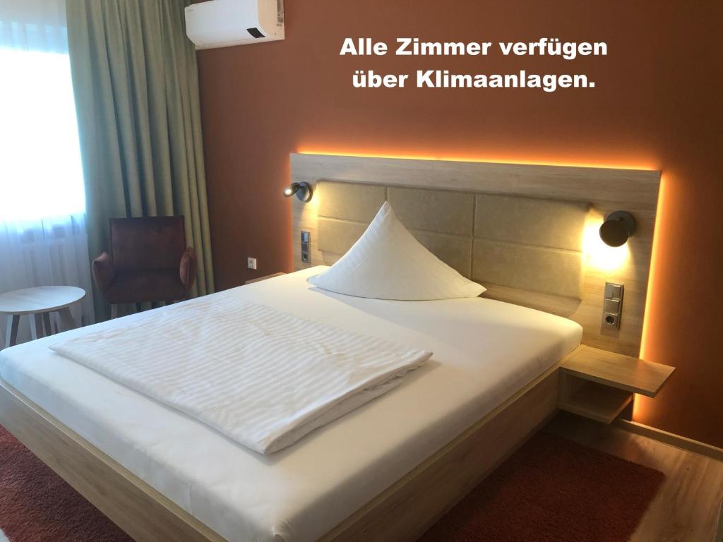 een bed in een hotelkamer met een witte deken erop bij Hotel Wilms in Keulen
