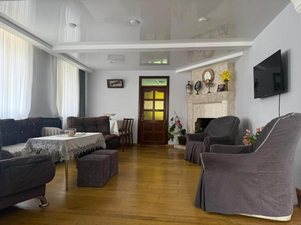 a living room with chairs and a table and a fireplace at Tsikhisdziri Hotel in Ts'ikhisdziri