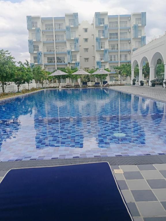 a large swimming pool in front of a large building at Inverse Travels in Negombo