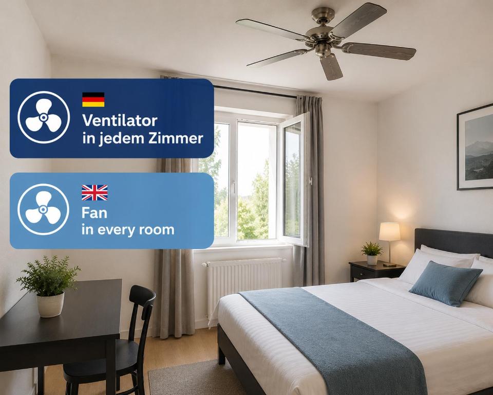 a bedroom with a bed and a desk with a ceiling fan at Hostel-Marburg-one in Marburg an der Lahn