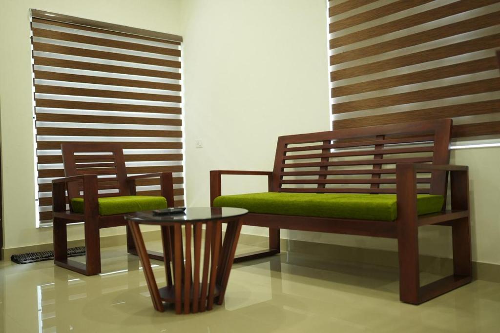 two benches and a table in a room at DHvillas in Wayanad