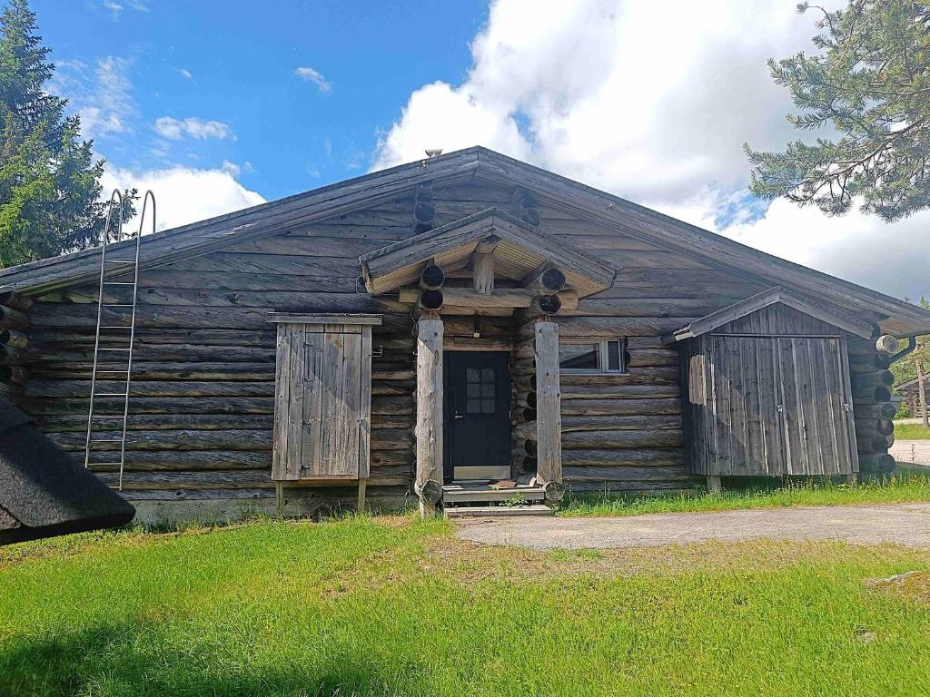 an old log cabin with a door in the grass at Revontuli 6 in Syöte