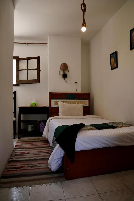a bedroom with a bed and a lamp in it at A private room by the rooftop in Cairo
