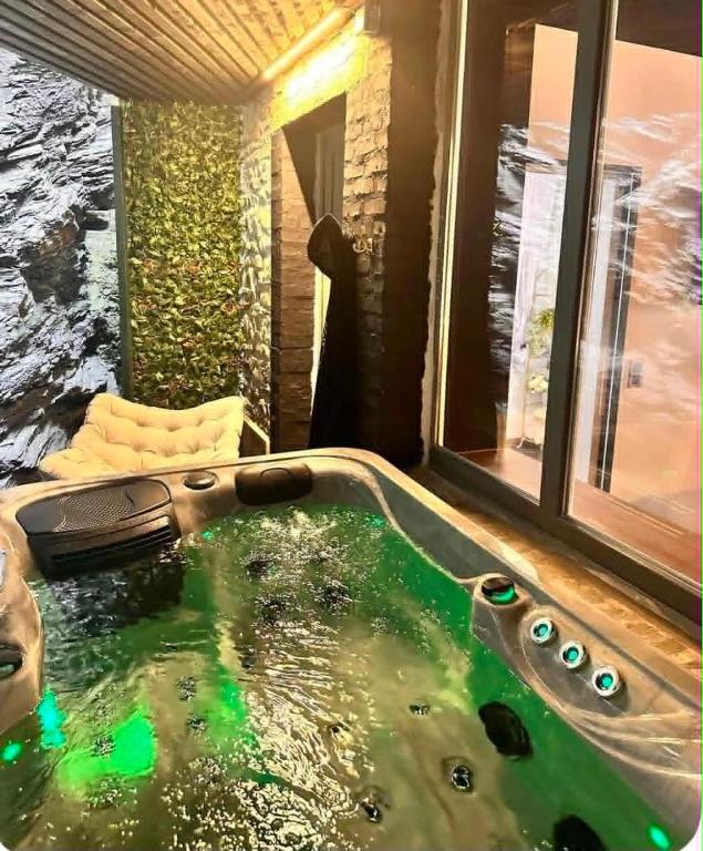 a bath tub in a room with a large window at Secret Rock - Jaccuzi privé in La-Roche-en-Ardenne