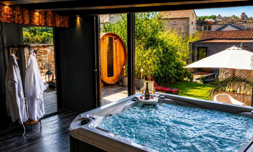 a bath tub with a view of a garden at 3 Waters Spa - Private Spa with Jacuzzi, Sauna & Hammam in Winenne