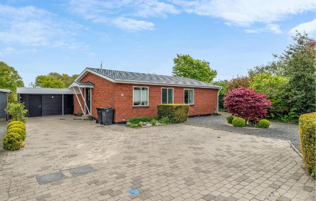 a brick house with a driveway in front of it at 2 Bedroom Pet Friendly Home In Ringkøbing in Ringkøbing