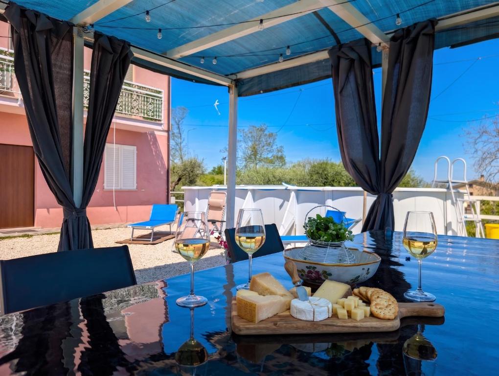 a table with glasses of wine and cheese at Villa with Sea View Parking in Lapedona