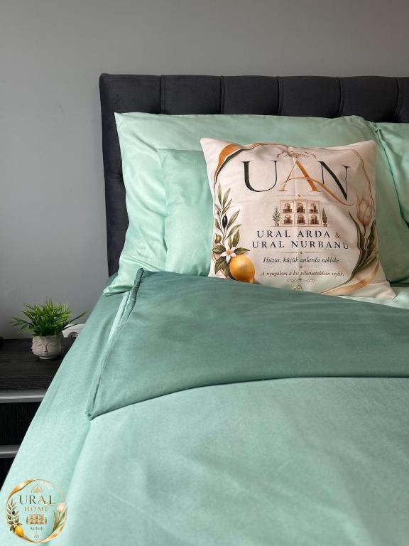 a green bed with a pillow on top of it at Ural Home in Székesfehérvár