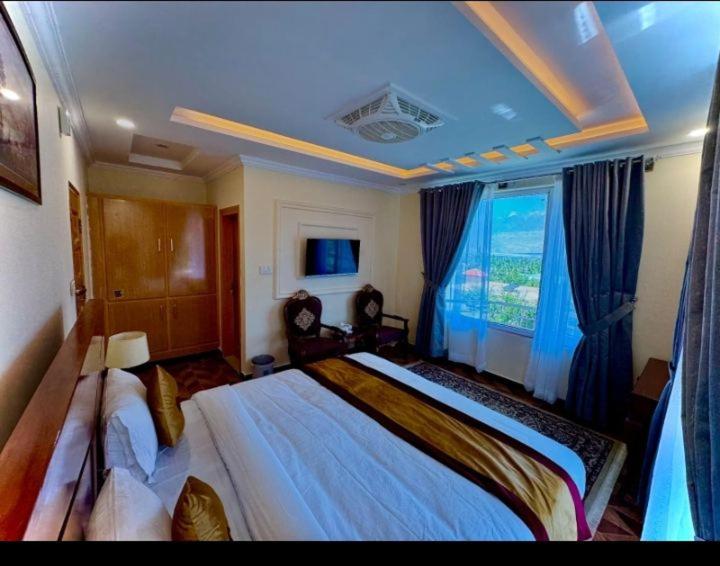 a bedroom with a large bed and a window at Relax in in Skardu