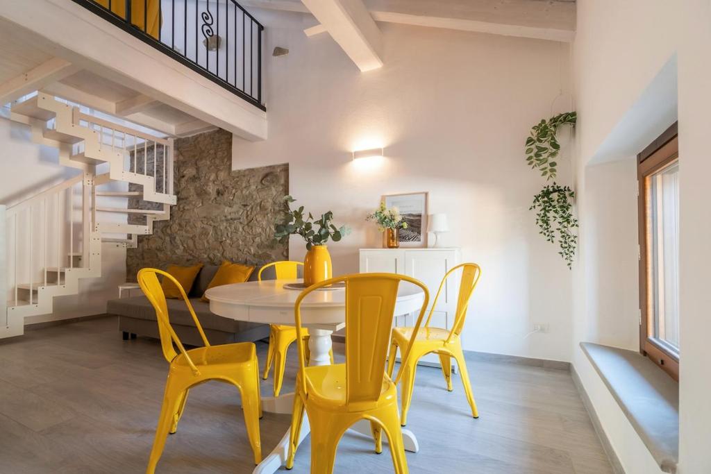 a dining room with yellow chairs and a table at L'appartamento giallo zafferano in Fanano