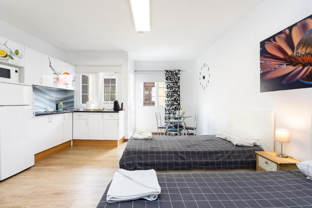 a white room with a bed and a kitchen at Maoli A Central Studio Icod de los Vinos in Icod de los Vinos