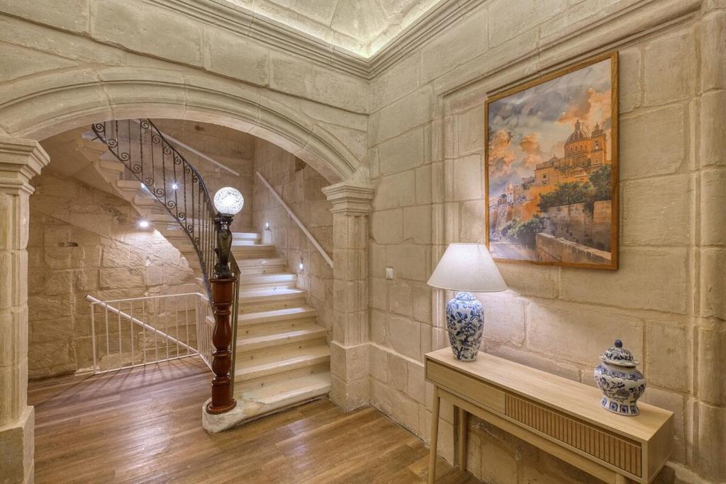 a staircase in a building with a painting and a vase on a table at Dar Vitorja in Senglea