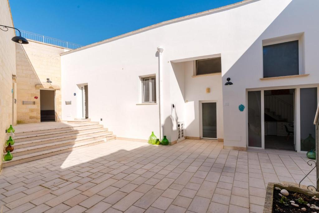 an empty courtyard of a white building with stairs at Dimora storica Jolanda a Uggiano in Uggiano la Chiesa